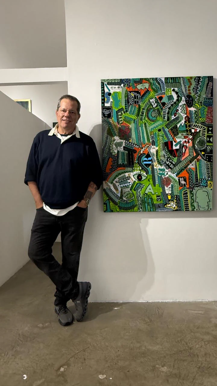 Alessandro standing beside a green painting during an exhibition in 2026.
