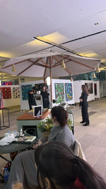 Exhibition installation in progress with artworks arranged across a large hall.