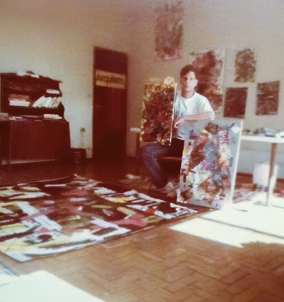 Historical photograph of Alessandro working among paintings in his studio.